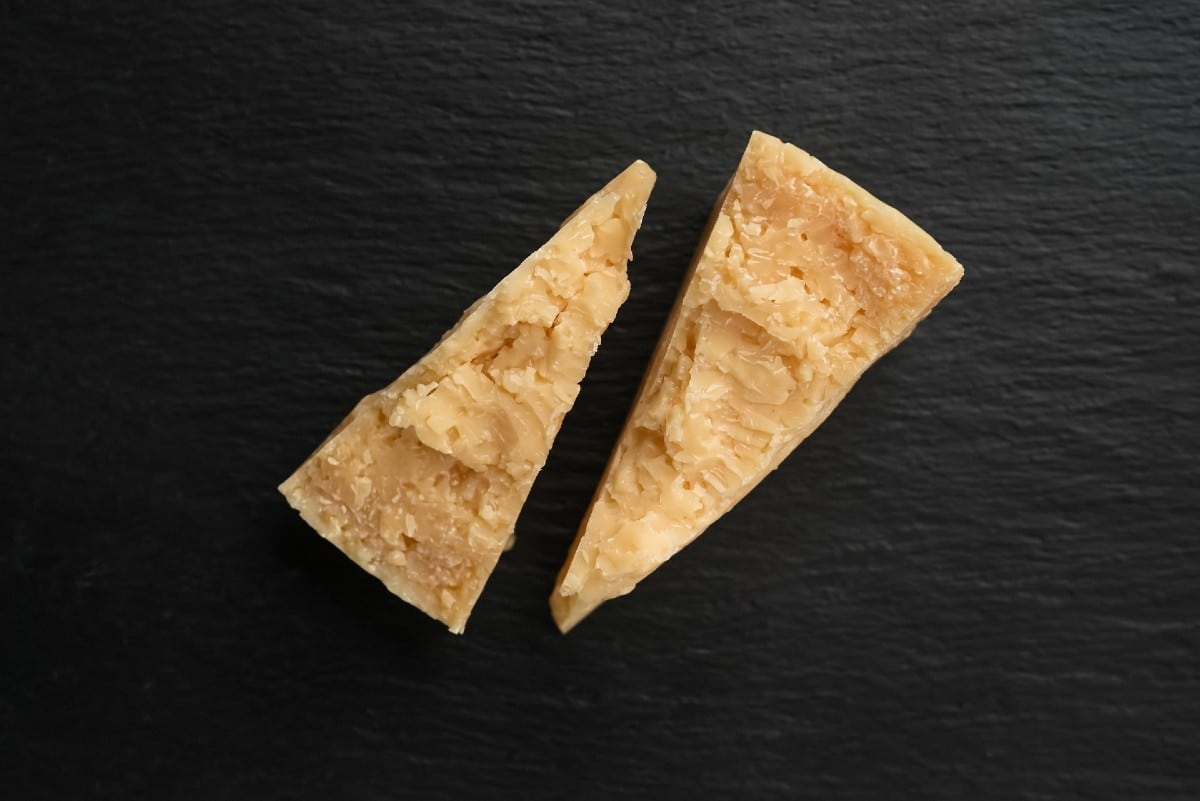 Due pezzi di formaggio Parmigiano Reggiano e Grana Padano - Differenze Blog Gustoemilia